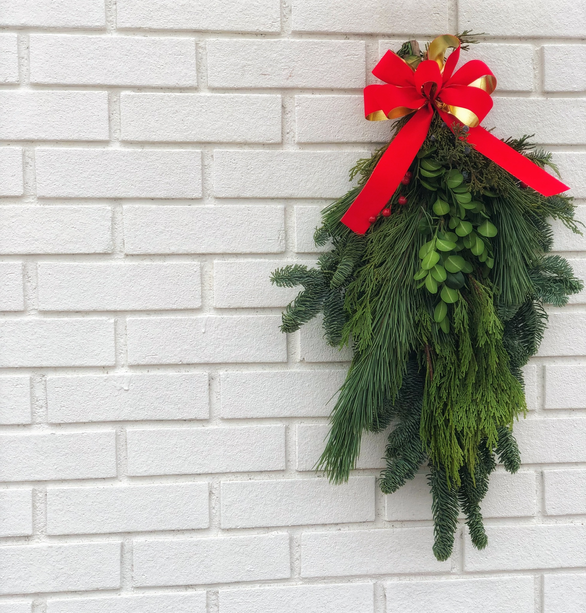 A simple mistletoe wreath with red bow